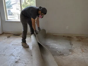Worker lifting tile from a floor