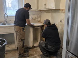 Workers removing kitchen cabinets