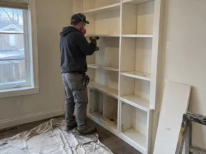 Worker removing a built-in shelving unit